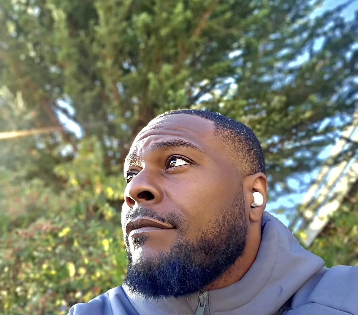 Garry Tipler outdoors under the trees, looking up.